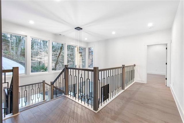 hallway featuring recessed lighting, wood finished floors, and baseboards