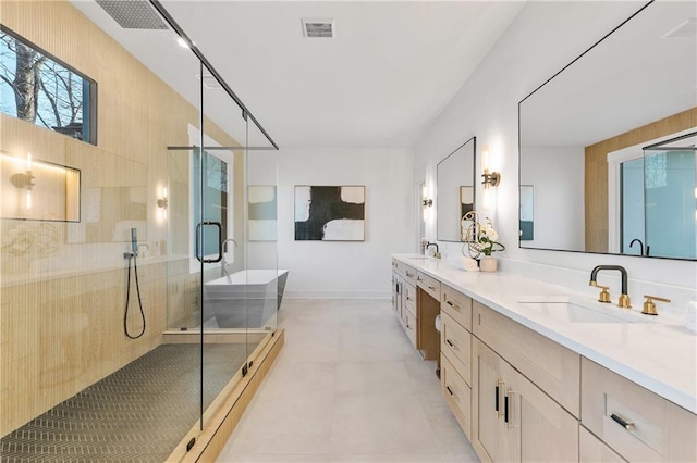 bathroom with a stall shower, visible vents, a sink, and double vanity