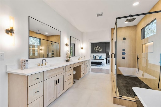 ensuite bathroom featuring plenty of natural light, a stall shower, visible vents, and a sink