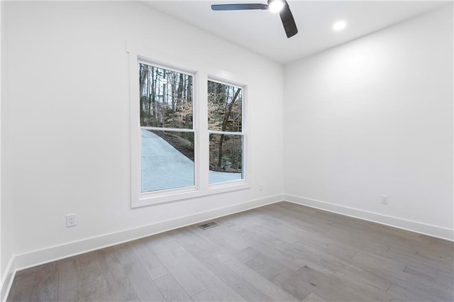 unfurnished room featuring recessed lighting, visible vents, a ceiling fan, wood finished floors, and baseboards