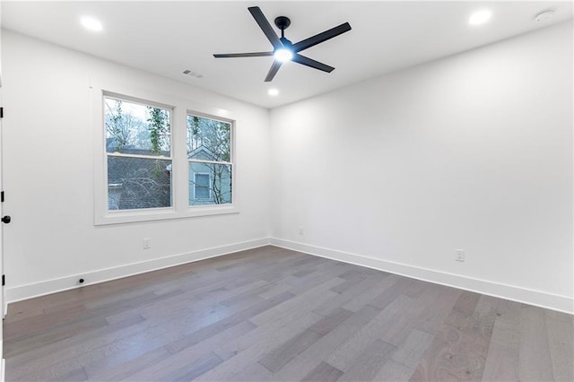 empty room featuring dark wood finished floors, recessed lighting, visible vents, ceiling fan, and baseboards