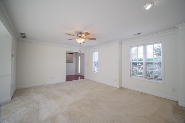 spare room with crown molding, light colored carpet, and ceiling fan