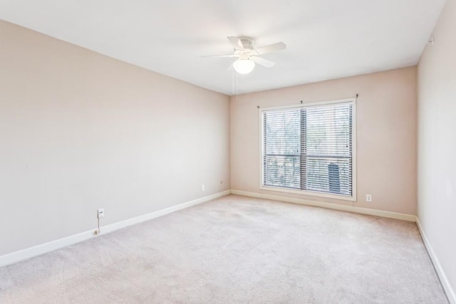 spare room featuring light carpet and ceiling fan