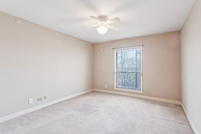 spare room featuring light carpet and ceiling fan