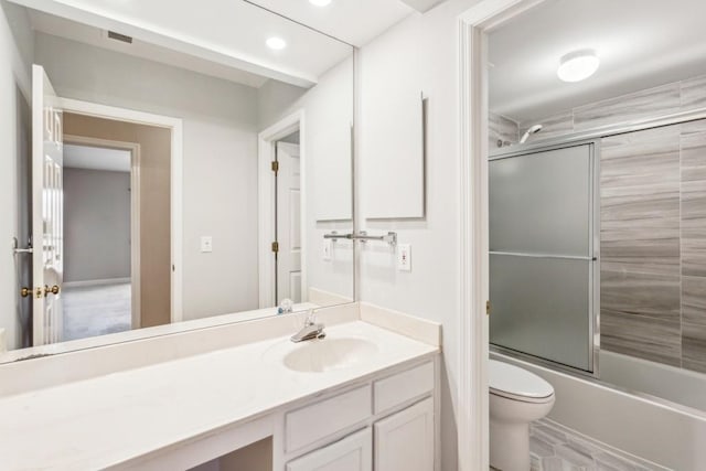 full bathroom featuring vanity, toilet, and combined bath / shower with glass door