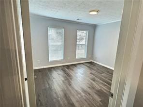 unfurnished room with ornamental molding, wood finished floors, and baseboards