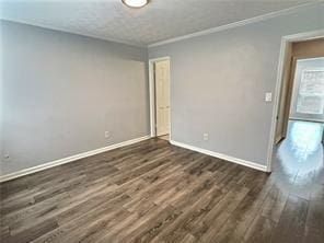 unfurnished room with crown molding, baseboards, and wood finished floors