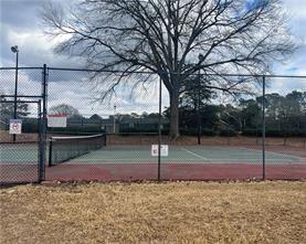 view of tennis court with community basketball court and fence