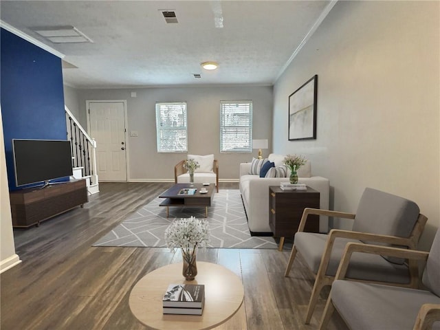 living room featuring baseboards, visible vents, wood finished floors, stairs, and crown molding