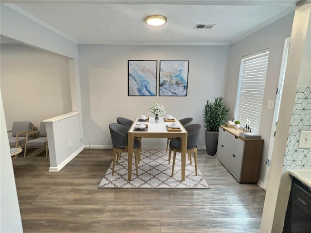 dining area with visible vents, crown molding, baseboards, and wood finished floors