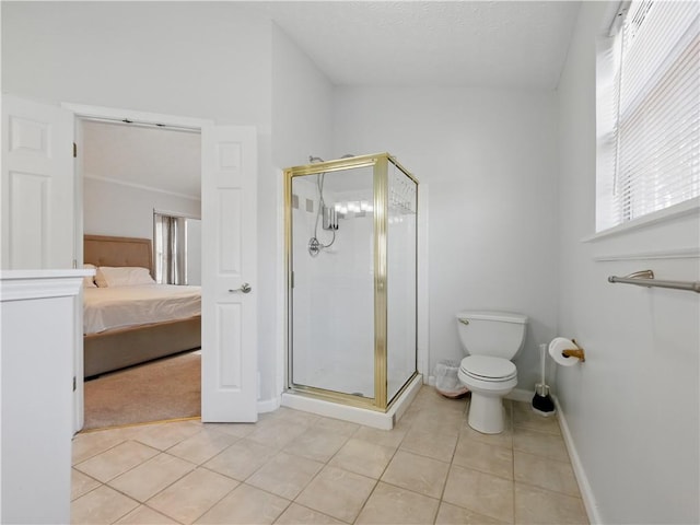 ensuite bathroom featuring baseboards, toilet, ensuite bath, tile patterned floors, and a shower stall