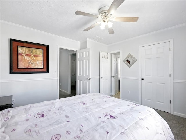 carpeted bedroom featuring baseboards, a textured ceiling, a ceiling fan, and crown molding