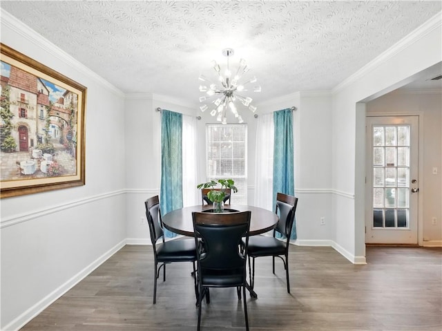 dining space with an inviting chandelier, ornamental molding, a textured ceiling, wood finished floors, and baseboards