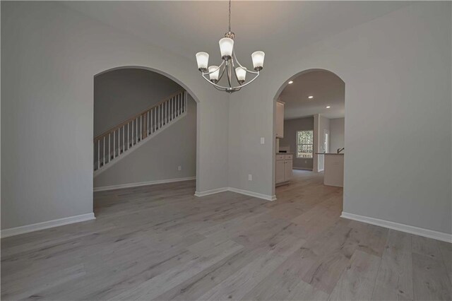 unfurnished room featuring light hardwood / wood-style floors and a chandelier