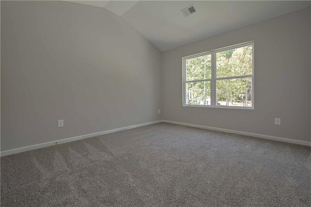 carpeted spare room featuring lofted ceiling