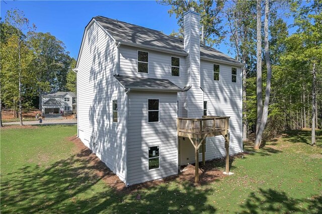 back of house with a deck and a yard