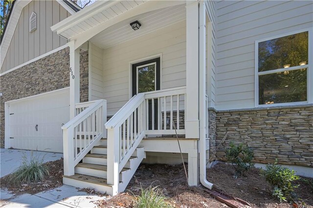 entrance to property featuring a porch and a garage