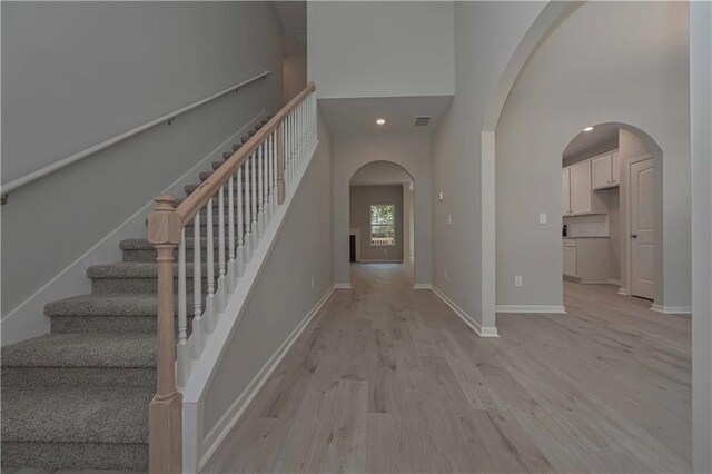 foyer featuring a high ceiling and light hardwood / wood-style flooring