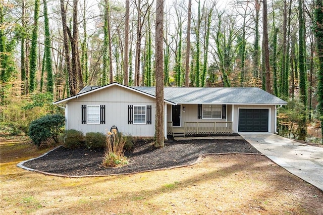 single story home with covered porch, an attached garage, and concrete driveway