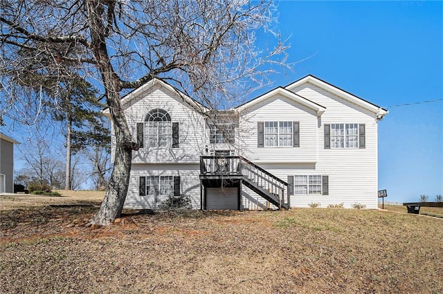 view of front of house featuring stairway, a deck, and a front yard