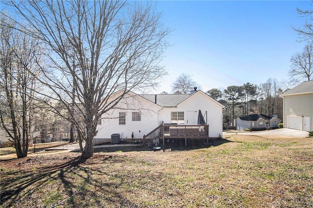 back of property with a yard, a wooden deck, and central AC