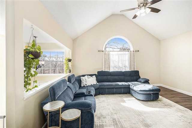 living room featuring lofted ceiling, a ceiling fan, plenty of natural light, and wood finished floors