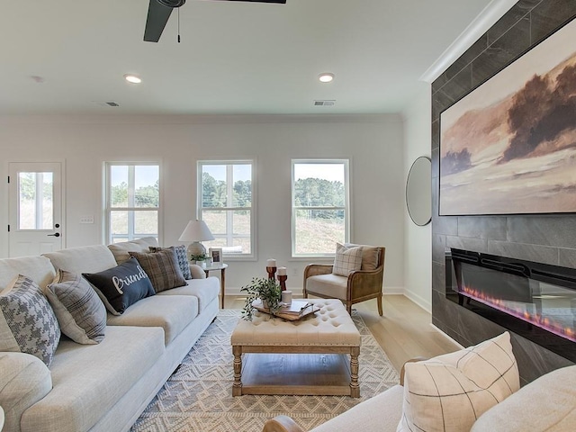 107 Winsome Way, Woodstock, GA 30188 - living room featuring a ceiling fan, crown molding, a tile fireplace, light wood-style floors, and recessed lighting