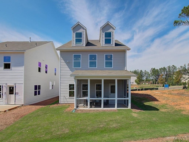 rear view of house with a sunroom and a yard