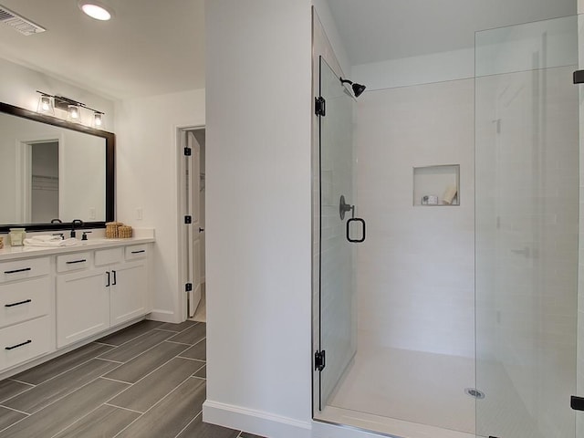 107 Winsome Way, Woodstock, GA 30188 - full bath featuring visible vents, wood finish floors, a stall shower, vanity, and baseboards