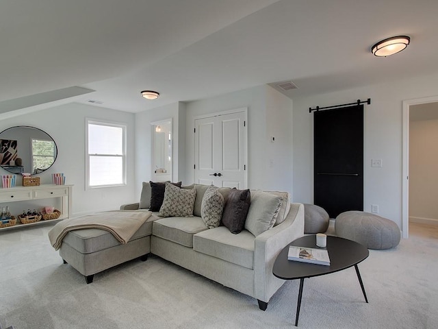 living room featuring a barn door and light carpet