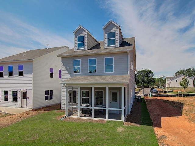 rear view of property with a yard and a sunroom