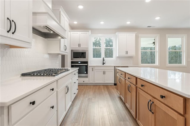 2719 Byess Ct, Marietta, GA 30064 - kitchen featuring stainless steel appliances, custom exhaust hood, a sink, light wood-type flooring, and light countertops