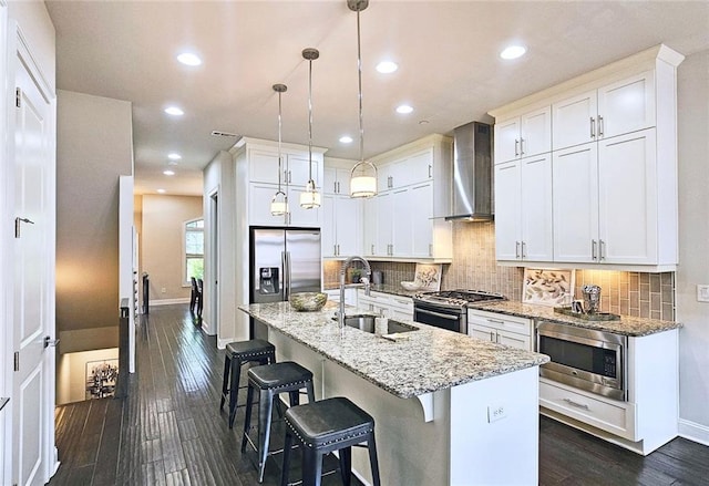 4107 Township Pkwy Unit 69, Sandy Springs, GA 30342 - kitchen with wall chimney range hood, appliances with stainless steel finishes, dark wood-style flooring, tasteful backsplash, and light stone counters