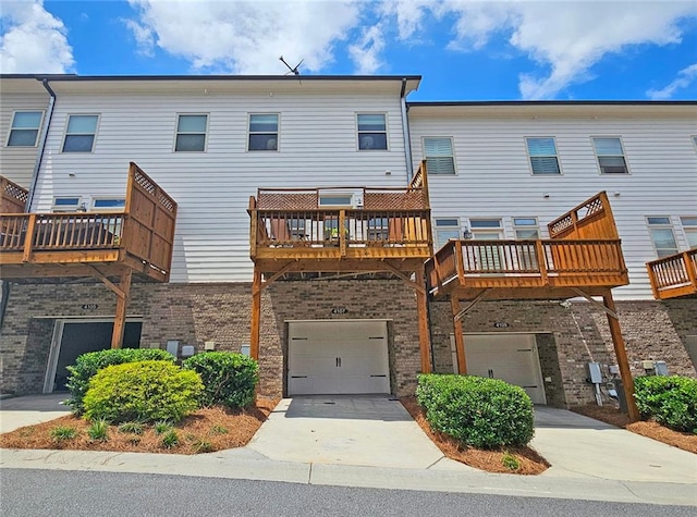 4107 Township Pkwy Unit 69, Sandy Springs, GA 30342 - rear view of house featuring driveway, a garage, brick siding, and a wooden deck