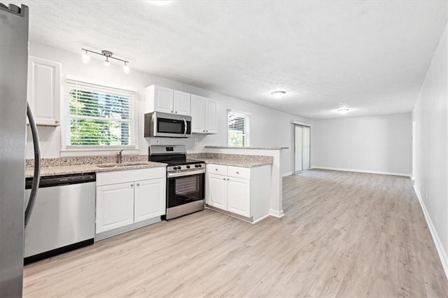 kitchen featuring light wood-type flooring, stainless steel appliances, sink, and white cabinets