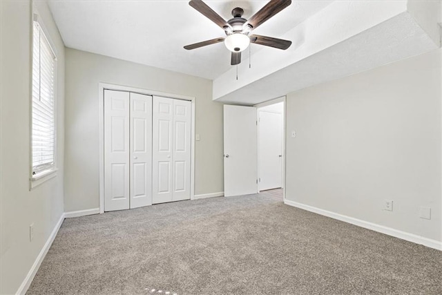 unfurnished bedroom featuring carpet floors, ceiling fan, and a closet