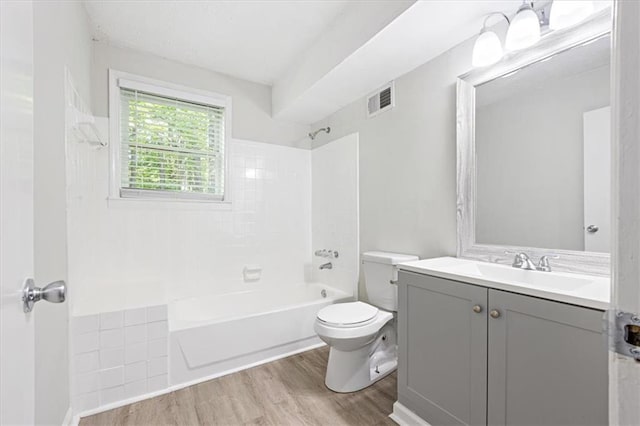 full bathroom featuring tiled shower / bath, vanity, toilet, and hardwood / wood-style floors