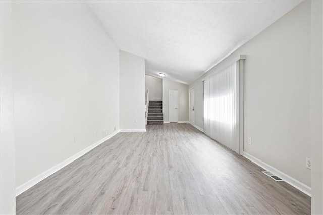 unfurnished living room with vaulted ceiling and light hardwood / wood-style floors