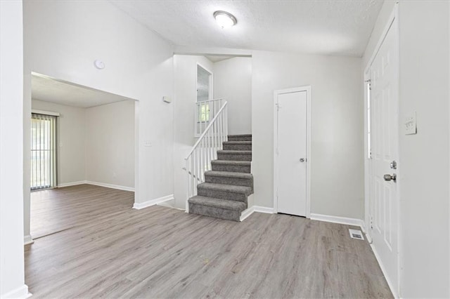 foyer with light hardwood / wood-style flooring and a textured ceiling