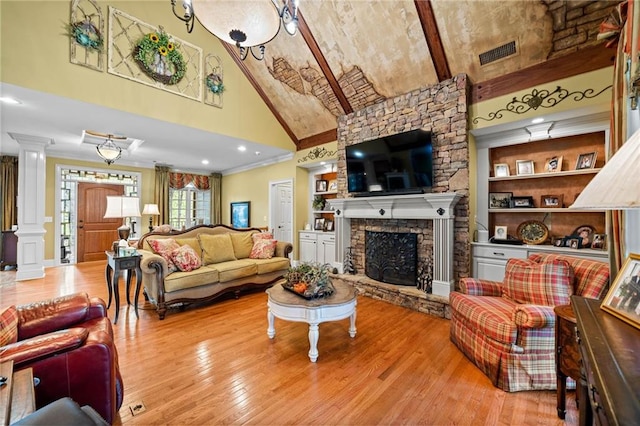 living room featuring hardwood / wood-style floors, visible vents, ornate columns, high vaulted ceiling, and ornamental molding