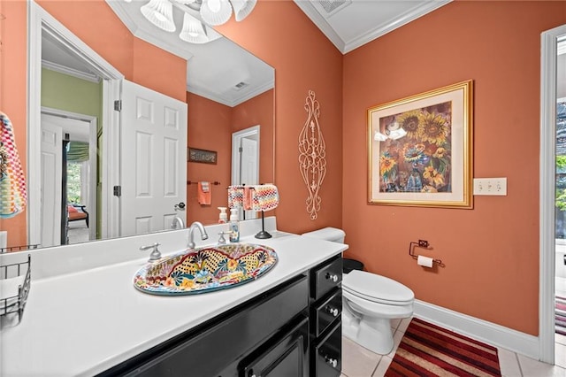 bathroom featuring baseboards, vanity, toilet, and crown molding