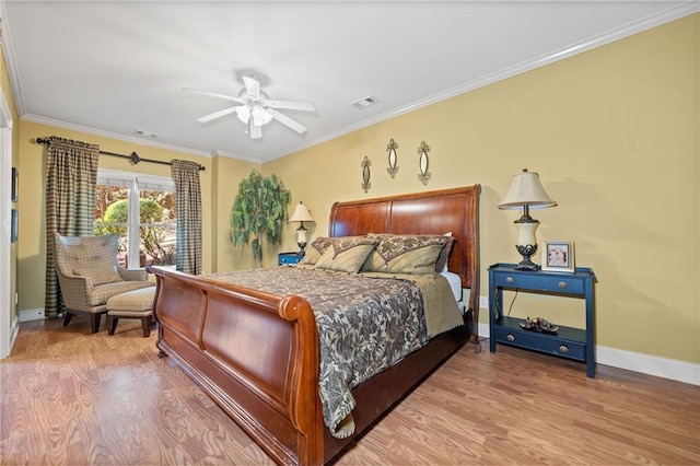 bedroom with visible vents, crown molding, and wood finished floors