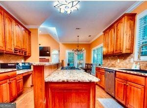 1090 Crown River Pkwy, Mcdonough, GA 30252 - kitchen featuring a chandelier, stainless steel dishwasher, a kitchen island, tasteful backsplash, and crown molding