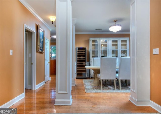 1090 Crown River Pkwy, Mcdonough, GA 30252 - hall with beverage cooler, decorative columns, wood finished floors, baseboards, and ornamental molding