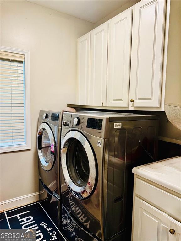 1090 Crown River Pkwy, Mcdonough, GA 30252 - laundry area with washer and clothes dryer, cabinet space, and baseboards