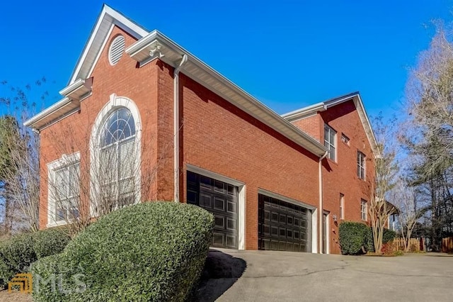 1090 Crown River Pkwy, Mcdonough, GA 30252 - view of side of property with brick siding, driveway, and an attached garage