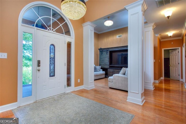 1090 Crown River Pkwy, Mcdonough, GA 30252 - foyer with decorative columns, light wood finished floors, baseboards, ornamental molding, and a chandelier