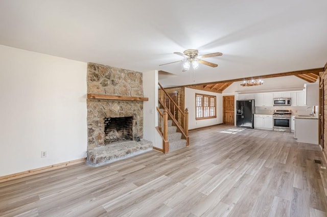 unfurnished living room with vaulted ceiling with beams, ceiling fan, a fireplace, sink, and light hardwood / wood-style flooring