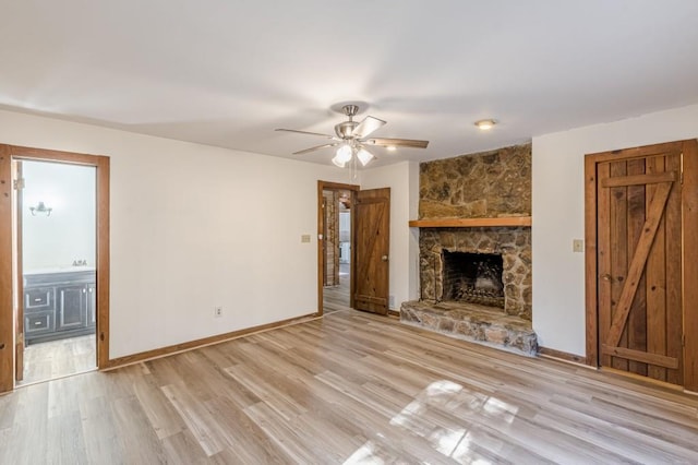 unfurnished living room featuring a fireplace, ceiling fan, and light hardwood / wood-style floors