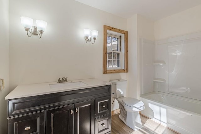 full bathroom featuring toilet, wood-type flooring, vanity, and bathtub / shower combination